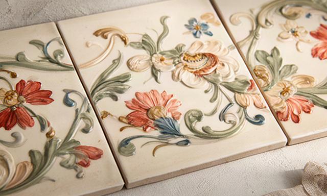 Decori floreali dipinti a mano su piastrelle chiare posate come fascia ornamentale
